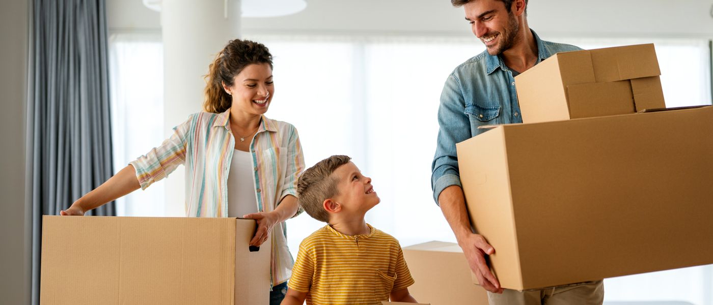 Familie zieht mit Umzugskartons in eine neue Wohnung ein